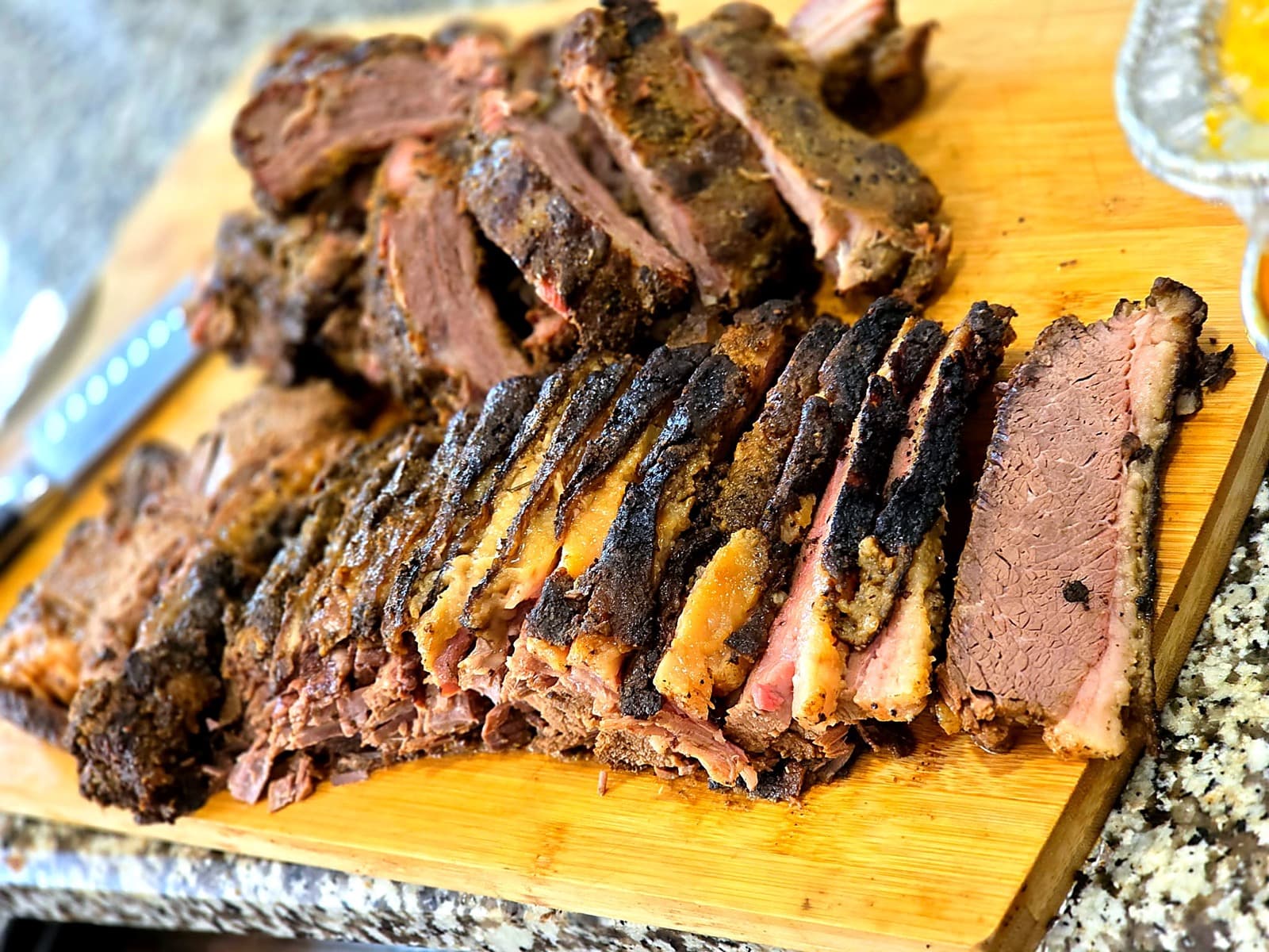 Hand-sliced smoked brisket on a cutting board