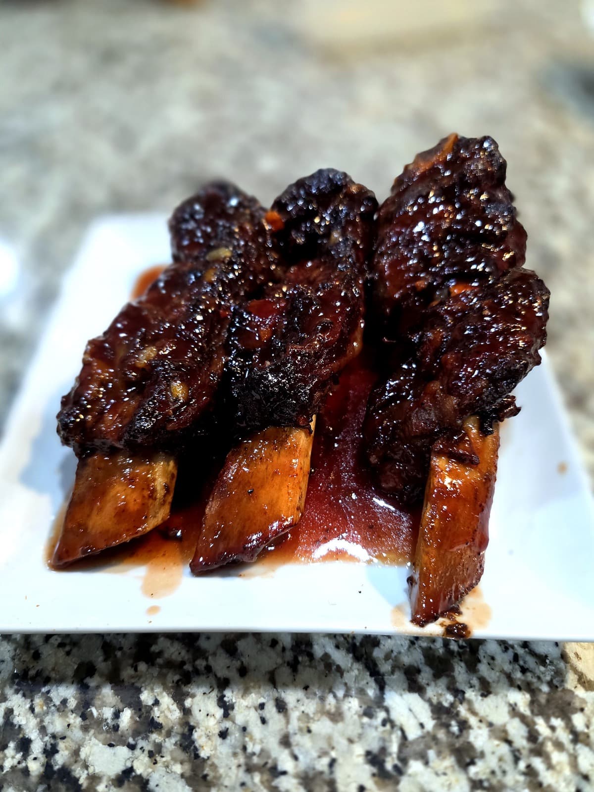 Glazed BBQ ribs plated with rich sauce