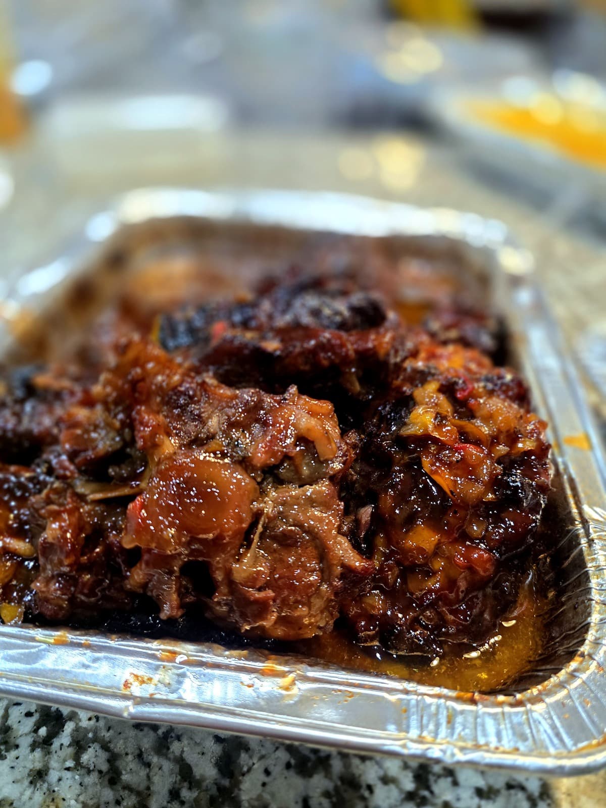 Saucy smoked meat close-up in a catering pan